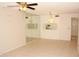 Bright living room featuring tile floors, ceiling fan, and mirrored accent wall with window to the kitchen at 19029 Us Highway 19 N # 2-12, Clearwater, FL 33764