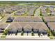 An aerial view of a meticulously planned community featuring townhomes and single-Gathering homes with a lake view at 19398 Great Intention Way, Lutz, FL 33558