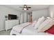 Bedroom with a ceiling fan, dresser with TV, and neutral decor at 19398 Great Intention Way, Lutz, FL 33558