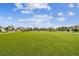 Expansive community field with vibrant green turf and surrounding residential homes at 19398 Great Intention Way, Lutz, FL 33558