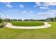 Lush community lawn perfect for recreation with paved walking path and blue skies at 19398 Great Intention Way, Lutz, FL 33558