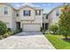 Charming townhome featuring a paved driveway, two-car garage, and well-maintained landscaping at 19398 Great Intention Way, Lutz, FL 33558