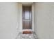 Close-up of the front door with a welcome mat on the beautiful gray stone floor at 19398 Great Intention Way, Lutz, FL 33558