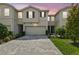 Charming townhome with a well-manicured lawn, brick driveway, attached garage, and neutral exterior paint at 19398 Great Intention Way, Lutz, FL 33558