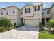 Inviting townhome with a paver driveway, attached garage, manicured lawn, and neutral exterior paint at 19398 Great Intention Way, Lutz, FL 33558