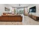 Inviting living room featuring a brown leather sofa, sliding glass doors, and wood-look flooring at 19398 Great Intention Way, Lutz, FL 33558
