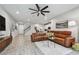 Open living area with tan leather sofas, ceiling fan, recessed lights, and light wood-look flooring at 19398 Great Intention Way, Lutz, FL 33558