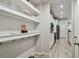 Hallway with pantry featuring shelves and door into kitchen at 19398 Great Intention Way, Lutz, FL 33558