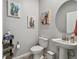 Charming powder room features a pedestal sink, round mirror, and unique wall art at 19398 Great Intention Way, Lutz, FL 33558