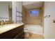 Bathroom features a vanity with granite countertop, bathtub, and tiled shower for a functional and elegant design at 2118 Ne Coachman Rd, Clearwater, FL 33765