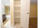 Hallway leads to a bathroom and bedroom with open shelving storage space at 2118 Ne Coachman Rd, Clearwater, FL 33765