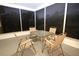 Enclosed patio featuring a glass table and four chairs with an outdoor view at 2118 Ne Coachman Rd, Clearwater, FL 33765