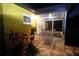Exterior view of a screened porch with patio, plants, and outdoor seating at 2118 Ne Coachman Rd, Clearwater, FL 33765