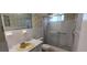 Well-lit bathroom equipped with a shower, sliding glass doors, and neutral cabinets at 2402 Ecuadorian Way # 20, Clearwater, FL 33763