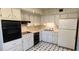 An efficient kitchen featuring black appliances and white cabinets over a tiled floor at 2402 Ecuadorian Way # 20, Clearwater, FL 33763