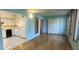 Living room area featuring hardwood floors, two large windows, and kitchen access at 2402 Ecuadorian Way # 20, Clearwater, FL 33763