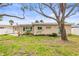 A spacious backyard features a large yard, mature trees, and a slider to the home at 2490 E Vina Del Mar Blvd, St Pete Beach, FL 33706