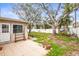 A spacious backyard features tile patio, mature trees, and a white privacy fence at 2490 E Vina Del Mar Blvd, St Pete Beach, FL 33706