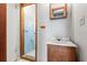 This vintage bathroom includes a single vanity, a mirror, and a blue tiled shower at 2490 E Vina Del Mar Blvd, St Pete Beach, FL 33706
