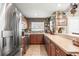 Well-lit kitchen featuring stainless steel appliances, wooden cabinetry, and a long countertop with bar-style seating at 2490 E Vina Del Mar Blvd, St Pete Beach, FL 33706