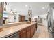 Open kitchen view with stainless steel appliances, wooden cabinets, and bar area into a living space at 2490 E Vina Del Mar Blvd, St Pete Beach, FL 33706