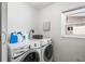 Laundry room with modern machines and a window for natural light at 2490 E Vina Del Mar Blvd, St Pete Beach, FL 33706
