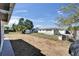 Fenced backyard with a gravel covering, shed, and mature trees at 2533 Limewood Dr, Holiday, FL 34690