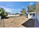 View of gravel-covered backyard surrounded by a chain-link fence, some trees, and the side of the home at 2533 Limewood Dr, Holiday, FL 34690