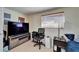 Cozy bedroom with neutral walls, large TV, comfortable chair, and warm, inviting lighting at 2533 Limewood Dr, Holiday, FL 34690