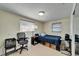 Bright bedroom with tiled floor, two windows, and a bed covered with a navy blue comforter at 2533 Limewood Dr, Holiday, FL 34690
