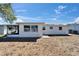 View of the back of the house with a gravel yard and screened-in porch at 2533 Limewood Dr, Holiday, FL 34690