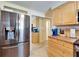 Modern kitchen with stainless steel fridge, light wood cabinetry, and tile floor at 2533 Limewood Dr, Holiday, FL 34690
