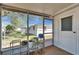 Cozy screened patio features potted plants, shelving, and an exterior door at 2533 Limewood Dr, Holiday, FL 34690