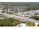 An aerial view shows a community with a pedestrian bridge, a pond and mature trees at 2700 Bayshore Blvd # 588, Dunedin, FL 34698