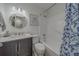Bathroom with updated vanity, updated lighting, circular mirror and shower-tub combo at 2700 Bayshore Blvd # 588, Dunedin, FL 34698