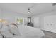 Bedroom featuring a white bed, gray dresser, ceiling fan, with white walls and wood look floors at 2700 Bayshore Blvd # 588, Dunedin, FL 34698