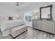 Cozy bedroom with a white bed, gray dresser, ceiling fan and wood look floors at 2700 Bayshore Blvd # 588, Dunedin, FL 34698
