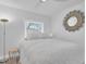 Bright bedroom featuring a ceiling fan, soft lighting, and a decorative sun mirror at 2700 Bayshore Blvd # 588, Dunedin, FL 34698