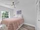 Inviting bedroom featuring a ceiling fan, soft lighting, and a pink patterned coverlet at 2700 Bayshore Blvd # 588, Dunedin, FL 34698