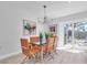 Modern dining room featuring a glass table with orange chairs and large sliding doors to the outside at 2700 Bayshore Blvd # 588, Dunedin, FL 34698