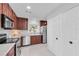 Spacious kitchen with stainless steel appliances, hardwood cabinets, and white tiled floor at 2700 Bayshore Blvd # 588, Dunedin, FL 34698