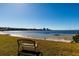 Waterfront view with park bench, calm waters, and sunny skies at 2700 Bayshore Blvd # 588, Dunedin, FL 34698