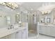 Elegant bathroom featuring double vanities, a glass-enclosed shower, and neutral tiling for a spa-like experience at 3006 W Angeles St, Tampa, FL 33629