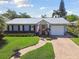 Beautiful single-story home featuring a metal roof, attached garage, and a brick paver driveway at 3006 W Angeles St, Tampa, FL 33629
