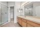 The bathroom has a large mirror, shower, and neutral-toned cabinets at 30103 Mossbank Dr, Wesley Chapel, FL 33543
