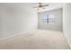 Neutral bedroom with ceiling fan, carpet and large window at 30103 Mossbank Dr, Wesley Chapel, FL 33543