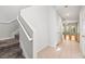 Hallway with carpeted stairs, tile flooring, and an open doorway to the living room at 30103 Mossbank Dr, Wesley Chapel, FL 33543