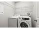 Convenient laundry area with modern appliances and shelving offers ease of use at 30103 Mossbank Dr, Wesley Chapel, FL 33543
