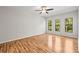Spacious living room with hardwood floors, three windows, and a ceiling fan at 30103 Mossbank Dr, Wesley Chapel, FL 33543