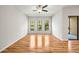 Spacious living room with hardwood floors, three windows, and a ceiling fan at 30103 Mossbank Dr, Wesley Chapel, FL 33543